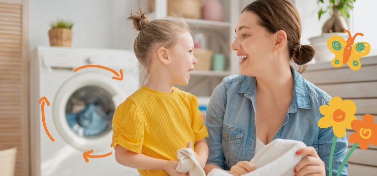 Mother and daughter smiling folding laundry in sunlit laundry room with spring flowers and butterfly